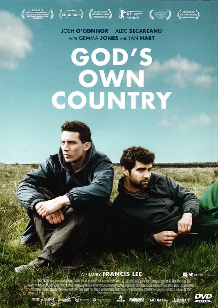 Poster for God's Own Country, with two men sitting side by side in an open field under a cloudy blue sky, looking out in opposite directions.